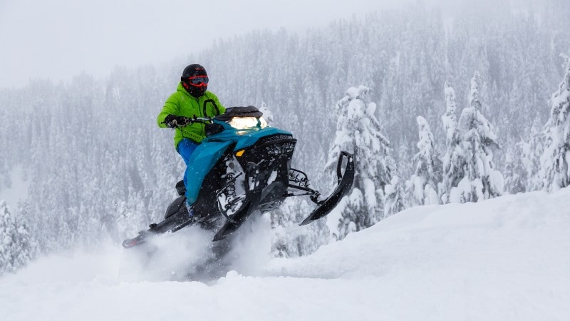 adventurous man riding a snowmobile