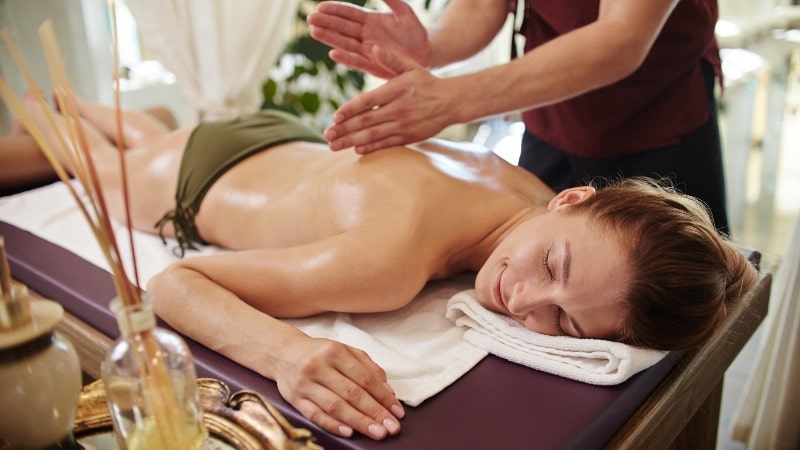 smiling women enjoying massage in spa